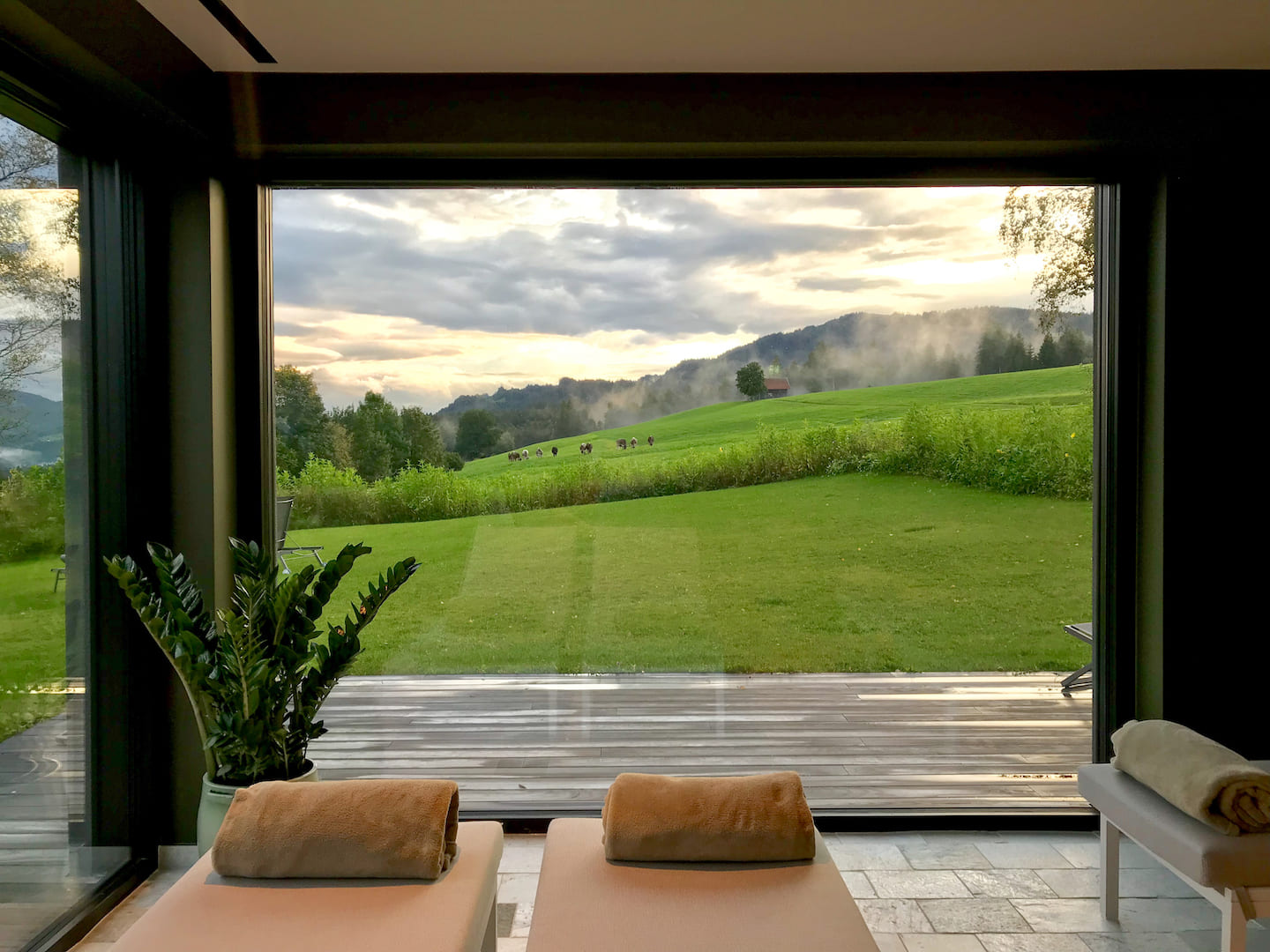 Select Green Hotels Alpenloge im Allgäu spa with glass front overlooking grazing cows
