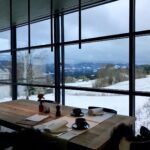 Select Green Hotels Alpenloge im Allgäu restaurant with glass front overlooking snowy hills